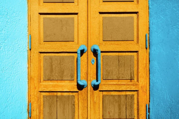 Wooden vintage door with door knobs. Ancient entrance concept background. Grunge aged and textured doorway backdrop.