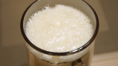 Eller Bira döküyor. Bir cam içine dökme lager kapatın. Ale cam dökülür. Soğuk ışık bira. Zanaat bira. Bir bardak bira light bira