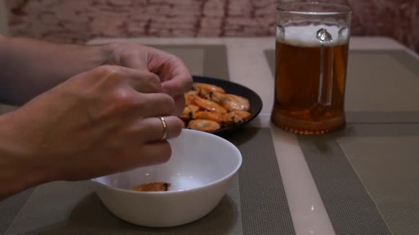 Un uomo che mangia gamberetti. Birra e gamberetti. L'uomo pulisce i gamberi — Video Stock