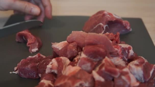 Kocken skär rått kött med kniven. Kocken skära fläskkött. Styckning av kött — Stockvideo