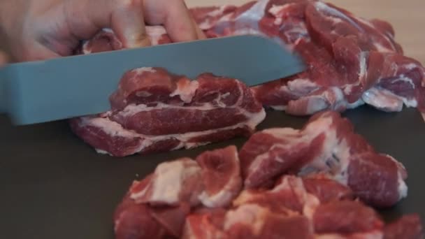 De chef-kok snijdt rauw vlees met het mes. Chef-kok snijden varkensvlees. Vlees snijden — Stockvideo