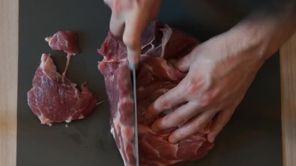 Kocken skär rått kött med kniven. Kocken skära fläskkött. Styckning av kött — Stockvideo