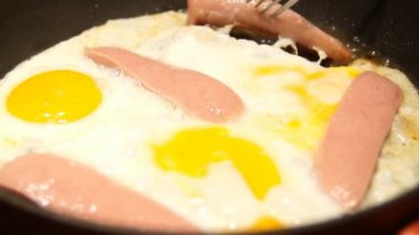 Sahanda yumurta pişirme. Şef pişirme omlet. Yumurta ve sosis kızartma