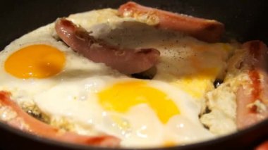 Sahanda yumurta pişirme. Şef pişirme omlet. Yumurta ve sosis kızartma