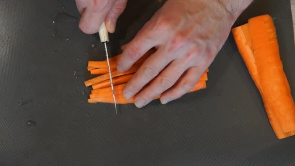 Шеф розрізає моркву. Процес приготування їжі. Руки розрізають моркву. Шеф-кухар нарізає моркву — стокове відео