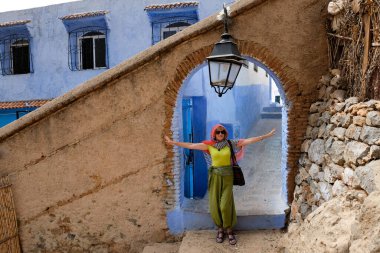 Orta Çağ Duvarı 'nın kapısında poz veren kadın turist - şehrin eski bir bölümü olan Chefchaouen, Fas.