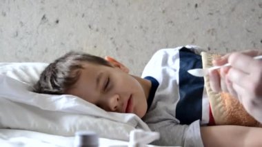 Ateşli bir geçmişi olan, hasta bir çocukla kanepede yatıp evde dinlenen bir bebek doktoru.