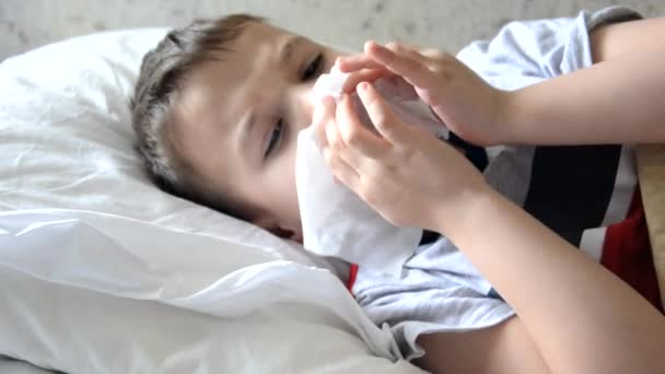 Βρεφικό φάρμακο με άρρωστο παιδί αγόρι ξαπλωμένο σε καναπέ με πυρετό, αναπαύεται στο σπίτι η μαμά δίνει φάρμακα στο γιο της, σιρόπι για το βήχα, σπρέι για το λαιμό, στάζει στη μύτη της, βάζει θερμόμετρο — Αρχείο Βίντεο