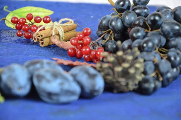 Осенний урожай, виноград, осенние опавшие листья, яблоки, сливы, корица, анис. Дикий виноград осенью под дождем — стоковое фото