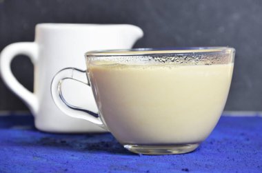 kahve ve krema ile şeffaf cam fincan. arka planda sütçü. karanlık anahtar
