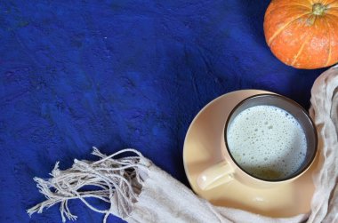 Kabak baharatlı latte veya fincan kahve, kuru yaprakları, koyu mavi masada hediyeler. Sonbahar veya kış sıcak içecek. Metin için alan, üst görünüm, kopyalama alanı