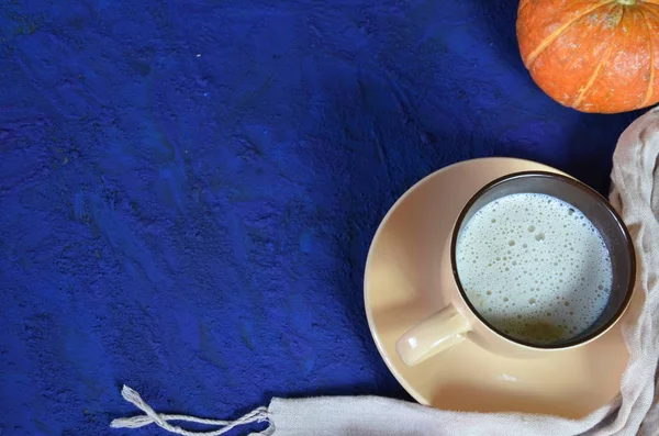 Calabaza con especias de café con leche o café en taza, hojas secas, regalos en la mesa azul oscuro. Bebida caliente de otoño o invierno. Espacio para texto, vista superior, espacio para copiar — Foto de Stock