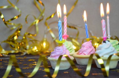 Cupcake renkli doğum günü mumları ile dekore edilmiştir. hediyeler, altın serpantin, yıldız, tatil kutlamak, parti.