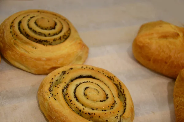 Frisch gebackene Zimtröllchen auf Stahlblech. Hausgemachte Zimtbrötchen zum Frühstück. Schwedische Süßgebäck Hintergrund in einem Bäckerladen. — Stockfoto