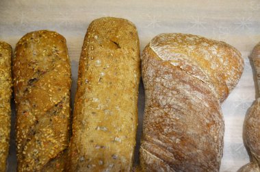 Yukarıdan gelen ekmek kağıdının üzerinde farklı şekillerde ekmek ruloları. Mutfak ya da fırın poster tasarımı.