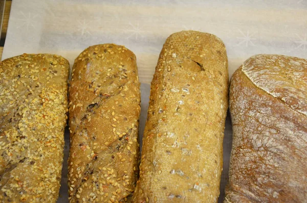 Verschiedene Arten von Brötchen auf Backpapier von oben. Plakatgestaltung für Küche oder Bäckerei. — Stockfoto