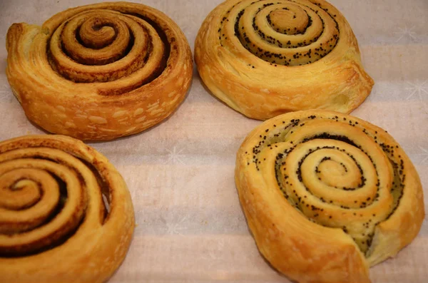 Çelik pişirme tepsisinde taze pişmiş tarçınlı rulo. Kahvaltıda ev yapımı tarçınlı çörek. Bir pastanede İsveç tatlısı geçmişi.