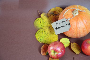 Şükran Günü. Balkabağı, sonbahar yapraklı ve elmalı balkabağı. Kahverengi arka planda sonbahar hasadı. Kutlama için Mutlu Şükran Günü Mektupları sehpaları. çatal ve bıçak