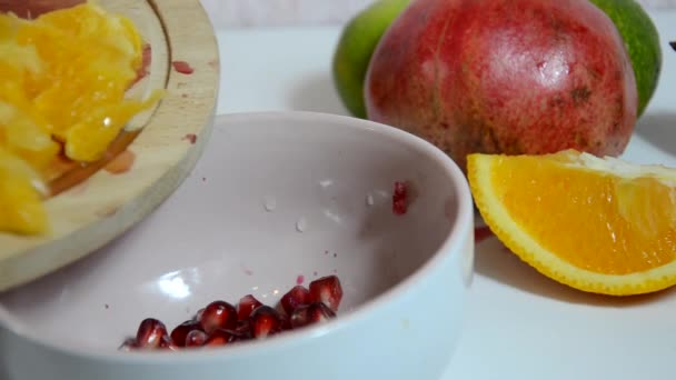 Ragazza buccia e taglia kiwi. Arancia affettata, kiwi e mele sul tavolo. tagli e bucce di arancia rossa succosa fresca per un'insalata di frutta. Dieta, poche calorie, vegetarianismo, vitamine naturali. — Video Stock