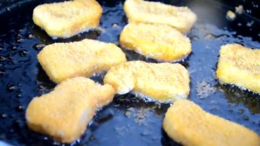 Kız tavada tereyağlı tavuk kızartması yapıyor. Lezzetli ev yapımı yemekler. Ya da fast food tavuk göğsü nuggetları.