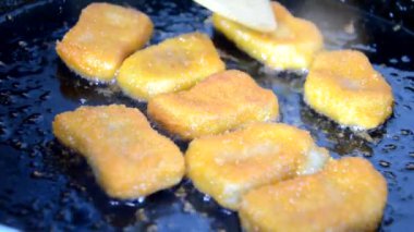 Kız tavada tereyağlı tavuk kızartması yapıyor. Lezzetli ev yapımı yemekler. Ya da fast food tavuk göğsü nuggetları.