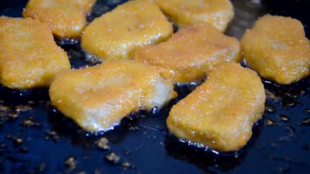 Meisje friet kip nuggets in een pan met boter. heerlijk zelfgemaakt eten. of fast food kip borst nuggets — Stockvideo