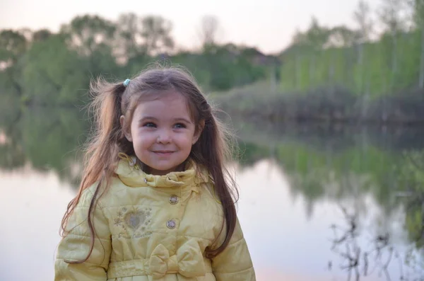 Mała Dziewczynka Jesiennej Lub Wiosennej Kurtce Stoi Nad Jeziorem Uśmiecha — Zdjęcie stockowe