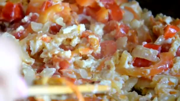 Desayuno con huevos revueltos Chica fríe los huevos en una sartén con verduras, tortilla, huevos fritos — Vídeo de stock