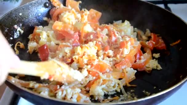 Desayuno con huevos revueltos Chica fríe los huevos en una sartén con verduras, tortilla, huevos fritos — Vídeos de Stock
