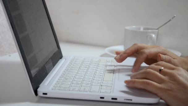 Primer plano de una mujer manos ocupadas escribiendo en una taza de café portátil en el fondo — Vídeos de Stock