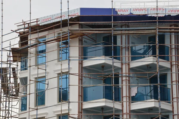 İskeleli bina inşaatı, arka plan için pencere ofis binası.