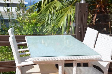 Denize bakan bir kafede boş bir masa, palmiye ağaçları. Dinlenme, tatil, yaz konsepti