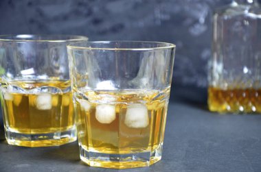 Buzlu soğuk çay ve siyah arka planda iki bardak nane şekeri iç. Alkolik ya da alkolsüz mahito. Limonlu ya da limonlu viski ya da selobant..