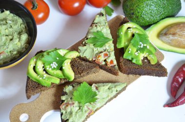 Guacamole ve ekmek. Beyaz arka planda avokadolu tost. Ev yapımı Meksika sağlıklı vejetaryen yemeği.