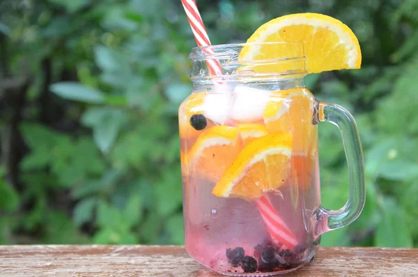 Infused detox water with orange, blueberry and mint. Ice cold summer cocktail or lemonade in glass mason jar, diet, body cleansing, healthy lifestyle