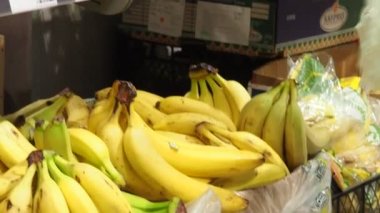 Güzel genç bir kadın yiyecek, meyve, elma, muz, domates, markette, süpermarkette portakal alıyor. Kız ürünleri, sebzeleri, meyveleri dükkandan seçiyor..