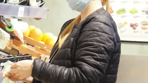 Mooie jonge mooie vrouw koopt eten, fruit, appels, bananen tomaten, sinaasappels in de markt, in de supermarkt.Girl kiest producten, groenten, fruit in de winkel.Winkelen, Veganistisch verkoopconcept. — Stockvideo