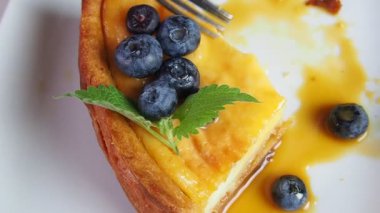 Kapalı kapılar ardında kremalı mascarpone peynirli kek yaban mersinli ve kış meyveli kek yiyen bir kız. New York peynirli keki. Kapatın. Noel tatlısı. Sağlıklı yiyecekler. Yaratıcı atmosfer dekorasyonu.