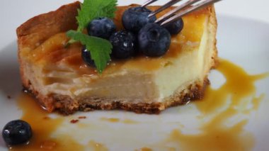 Kapalı kapılar ardında kremalı mascarpone peynirli kek yaban mersinli ve kış meyveli kek yiyen bir kız. New York peynirli keki. Kapatın. Noel tatlısı. Sağlıklı yiyecekler. Yaratıcı atmosfer dekorasyonu.