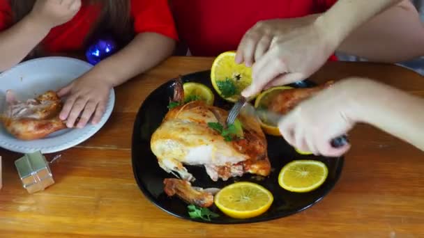 Moeder snijdt kip voor feestelijk diner Thanksgiving dag, Kerstmis of nieuwjaar, kinderen zitten aan de tafel. familie diner, oven gebakken kip, kalkoen curry — Stockvideo