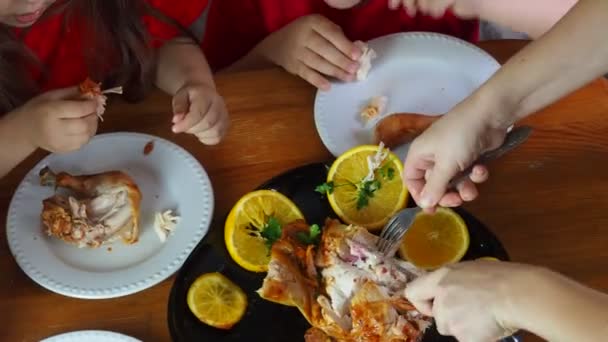 Mor skærer kylling til festlig middag taksigelsesdag, jul eller nytår, børn sidder ved bordet. familiemiddag, ovnbagt kylling, kalkunkarry – Stock-video