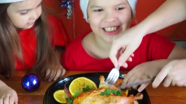 Mamma taglia pollo per la cena festiva giorno del Ringraziamento, Natale o Capodanno, i bambini si siedono a tavola. cena in famiglia, pollo al forno, curry di tacchino — Video Stock