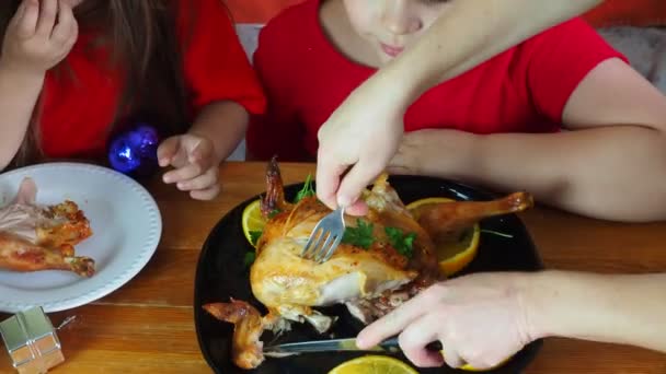 Mom cuts chicken for festive dinner thanksgiving day, christmas or new year, children sit at the table. family dinner, oven baked chicken, turkey curry — Stock Video