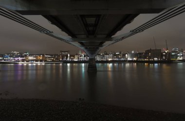 Kuzey bankanın altından Millenium Bridge gece Thames görünümü