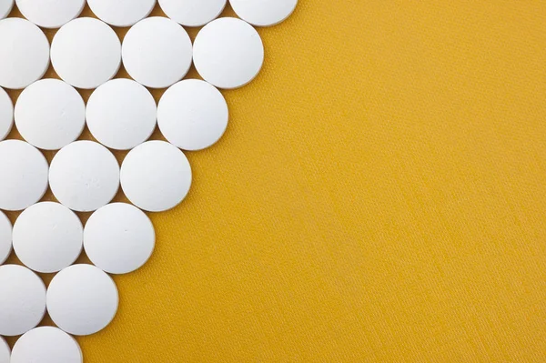 Duże Białe Tabletki Żółtym Tle Teksturowane Miejsca Dla Kopii — Zdjęcie stockowe