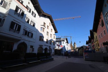 KITZBUEHEL, AUSTRIA - 8 Ağustos 2025: Geleneksel dağlık evler ve tarihi şehir merkezinde bir inşaat vinci ile sokak manzarası. Yüksek kalite fotoğraf