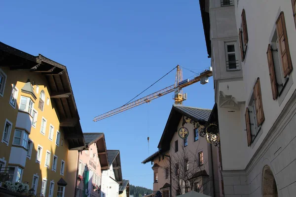 KITZBUEHEL, AUSTRIA - 8 Ağustos 2025: Eski Kitzbuehel kasabasında ahşap panjurlu renkli geleneksel binaların sokak manzarası. Yüksek kalite fotoğraf