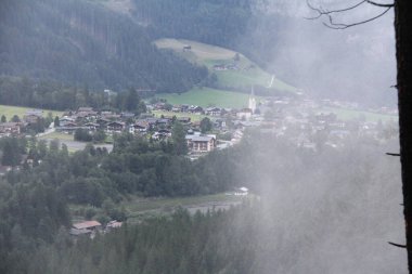 KRIMML, AUSTRIA - AUGUST 8, 2025: Scenic view of the village of Krimml with parish church and traditional alpine houses surrounded by mountains. High quality photo