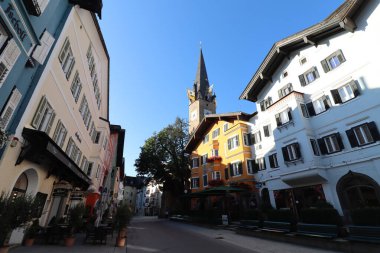 KITZBUEHEL, AUSTRIA - AUGUST 8, 2025: Colorful historic buildings and parish church tower in the old town of Kitzbuehel. High quality photo