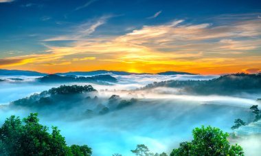 Hillside güneşin ufuk olarak üzerinde gündoğumu yansıtan ışık parlak sarı gökyüzü. Bulutlu sis kaplı vadiler sular altında çam ormanlar etkileyici güzellik highlands sabah oluşturmak.